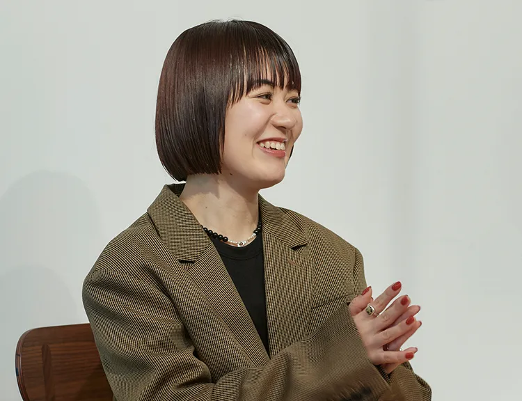 手を軽く合わせ、笑顔で話しているシオノさん