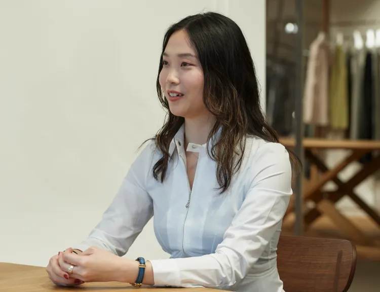 机に手を乗せて、受け答えをしているオオモトさん