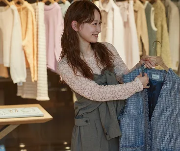 ツイードベストを手に取って、お客様に提案しているショウジさん