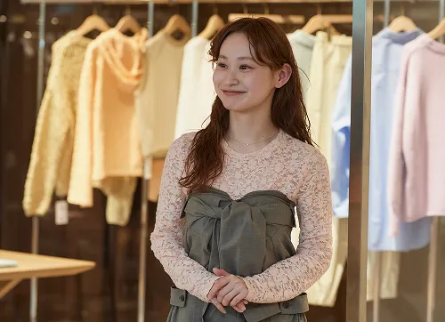 微笑みながら両手を前で軽く重ねて立っているショウジさん